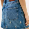 Minifalda vaquera de talle alto con escudo bordado Minifalda vaquera de talle alto con escudo bordado