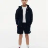 Pantalón corto de chándal para niño con logotipo de bandera en tonos Pantalón corto de chándal para niño con logotipo de bandera en tonos