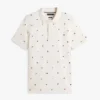 Polo de piqué con estampado de banderas en todo el cuerpo y corte regular